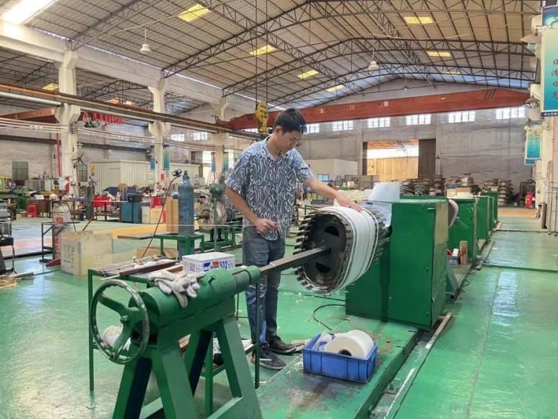 Coil winding production line, worker manufacturing transformer winding for oil immersed power transformers